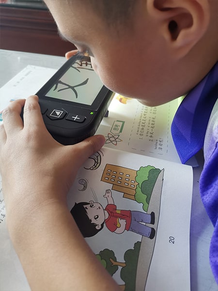 低视力小学生使用4.3寸手持式电子助视器看书学习
