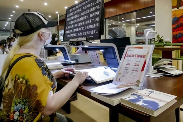 视障读者在杭图无障碍阅览室使用台式电子助视器看书