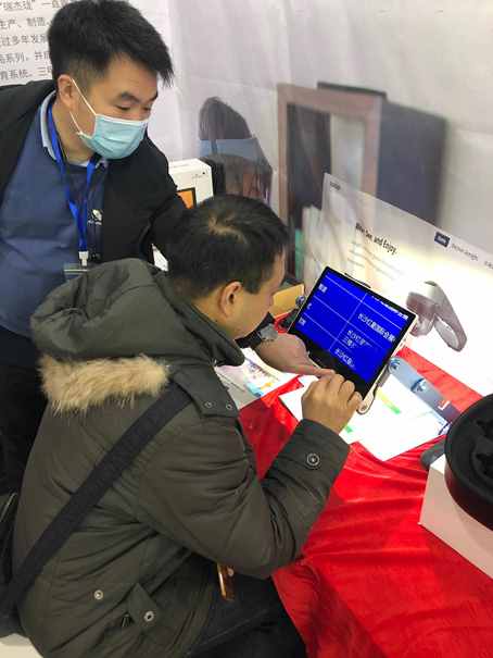 视障人士在瑞杰珑展位体验12寸便携式电子助视器