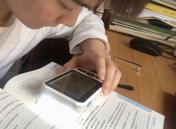 患有黄斑变性的低视力大学生使用4.3寸手持式电子助视器看书学习