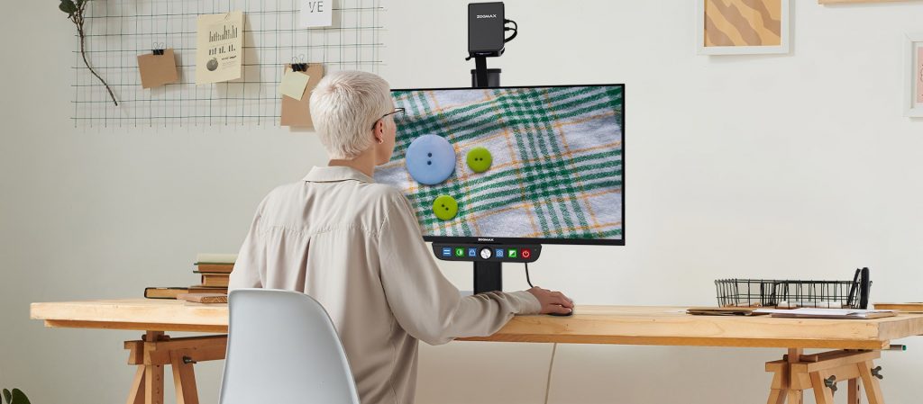 低视力用户正在使用luna eye台式助视器辨别纽扣颜色